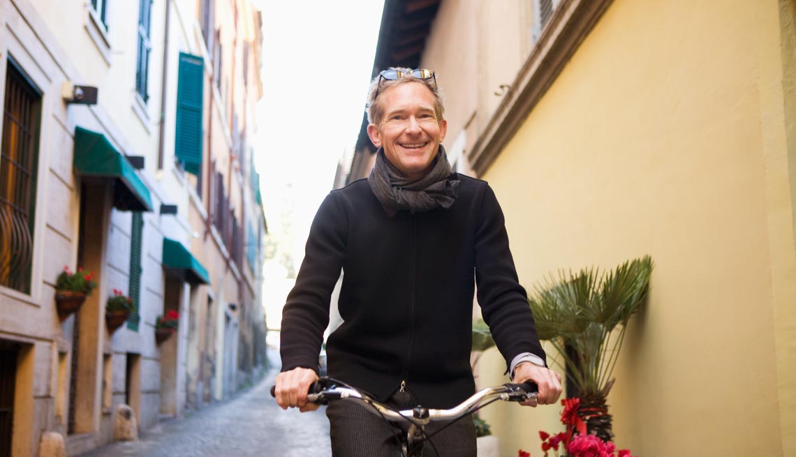 A man bikes on a narrow pavement, Stay Healthy on Vacation 